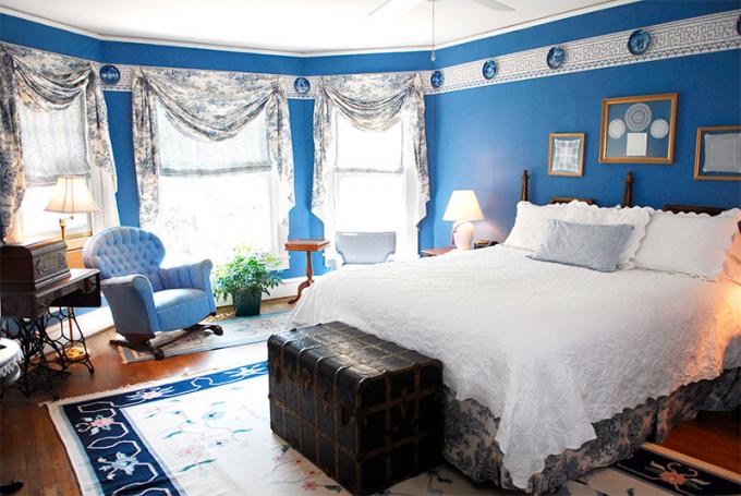 Foto av et soverom med blå vegger for å redusere plassen