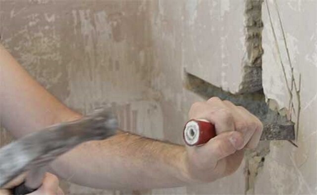 Shtroblenie vegg med en hammer og meisel