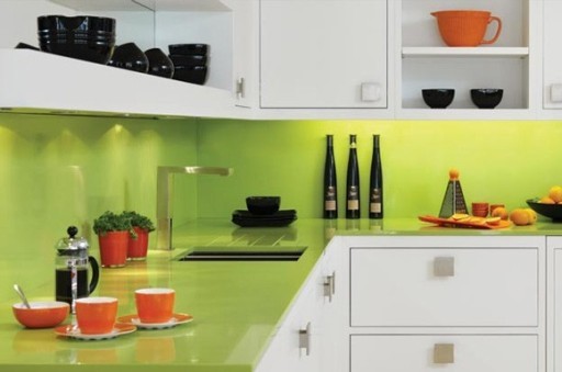 Benkeplaten og forkleet i en lys kalkskygge ser bra ut i kombinasjon med hvite kjøkkenfronter og oransje retter.